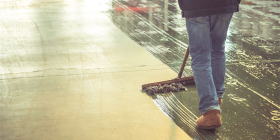 This image shows a man applying a concrete coating to a floor.
