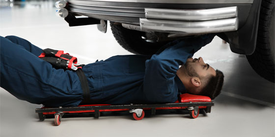 This image shows a mechanic fixing a car.