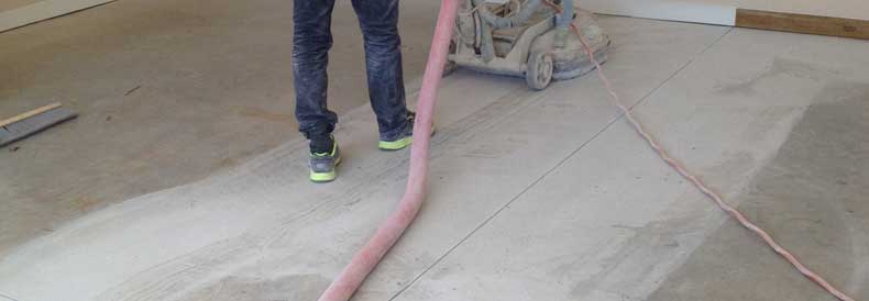 This image shows a man grinding the floor to make it smoother.