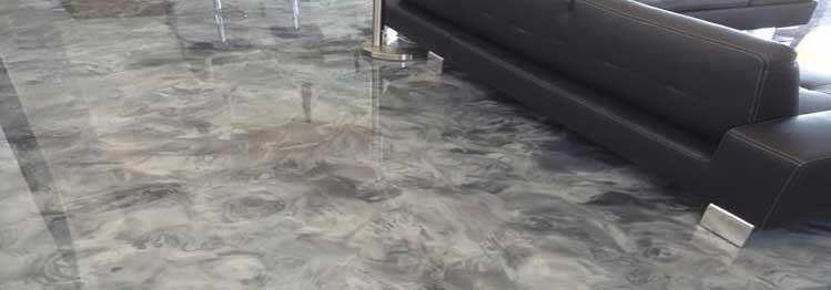 This image shows a living room with an epoxy floor. It has a combination of grey and white metallic epoxy.