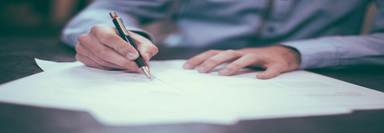 This image shows a man signing a contract.