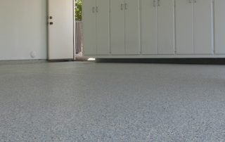 This image shows a garage floor with flake epoxy painted floor.