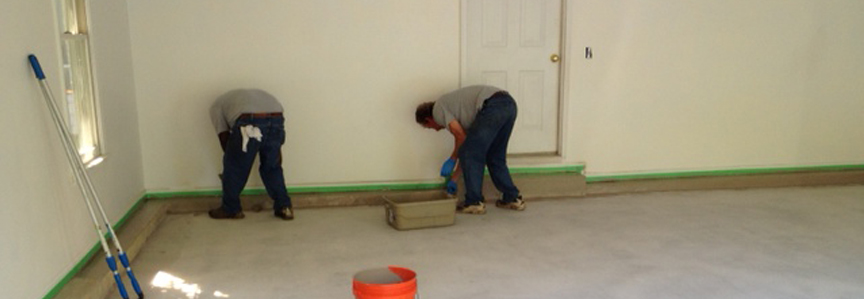 This image shows 2 men applying epoxy paint on a floor.